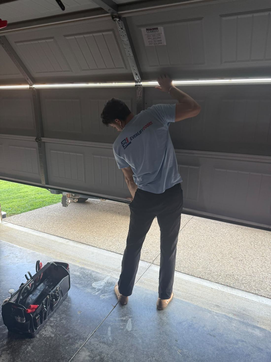 EverLift Doors technician aligning garage door panels during a repair visit at a Kentucky residence